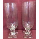 A pair of cut glass vases raised on pedestal stems with engraved detail and channelled design.