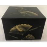 A Japanese black lacquer 2 sectional box with gilt fan detail.