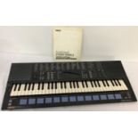 A vintage Yamaha Portasound PSS-680 Musicstation synthesizer with instruction manual.