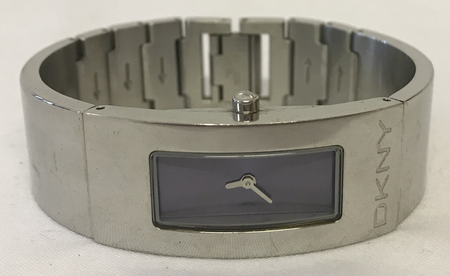 A ladies stainless steel bracelet watch by DKNY. Blue metallic face with silver hands.