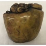 A decorative Oriental soapstone seal with carved dragon detail.