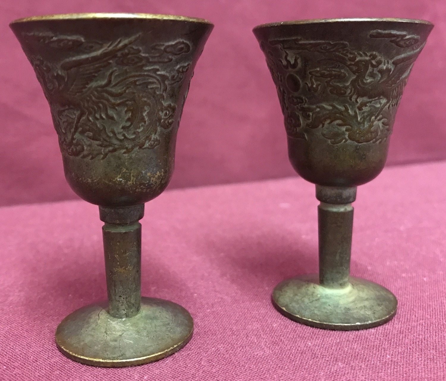 2 small Chinese bronze stemmed goblets with dragon design to outer bowl.