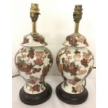 A pair of ceramic table lamps with floral and gilt decoration.