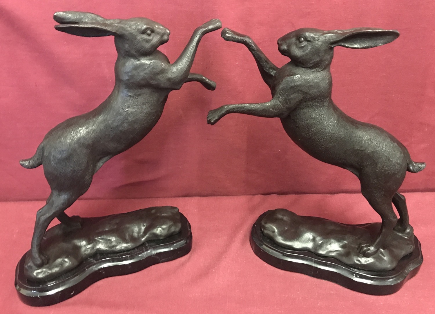 A pair of bronze "boxing hares" figurines mounted on marble bases.