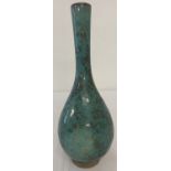A slim necked Chinese ceramic vase with blue/green speckled glaze.