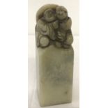 A square shaped oriental soapstone seal with carved figural detail to top.
