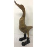 A wooden figurine of a duck wearing boots.