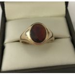A 9ct gold signet ring set with an oval garnet stone.
