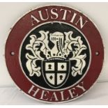 A painted cast metal, circular shaped, Austin Healey wall plaque.
