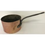A large antique copper saucepan with riveted handle and stamped with makers mark.