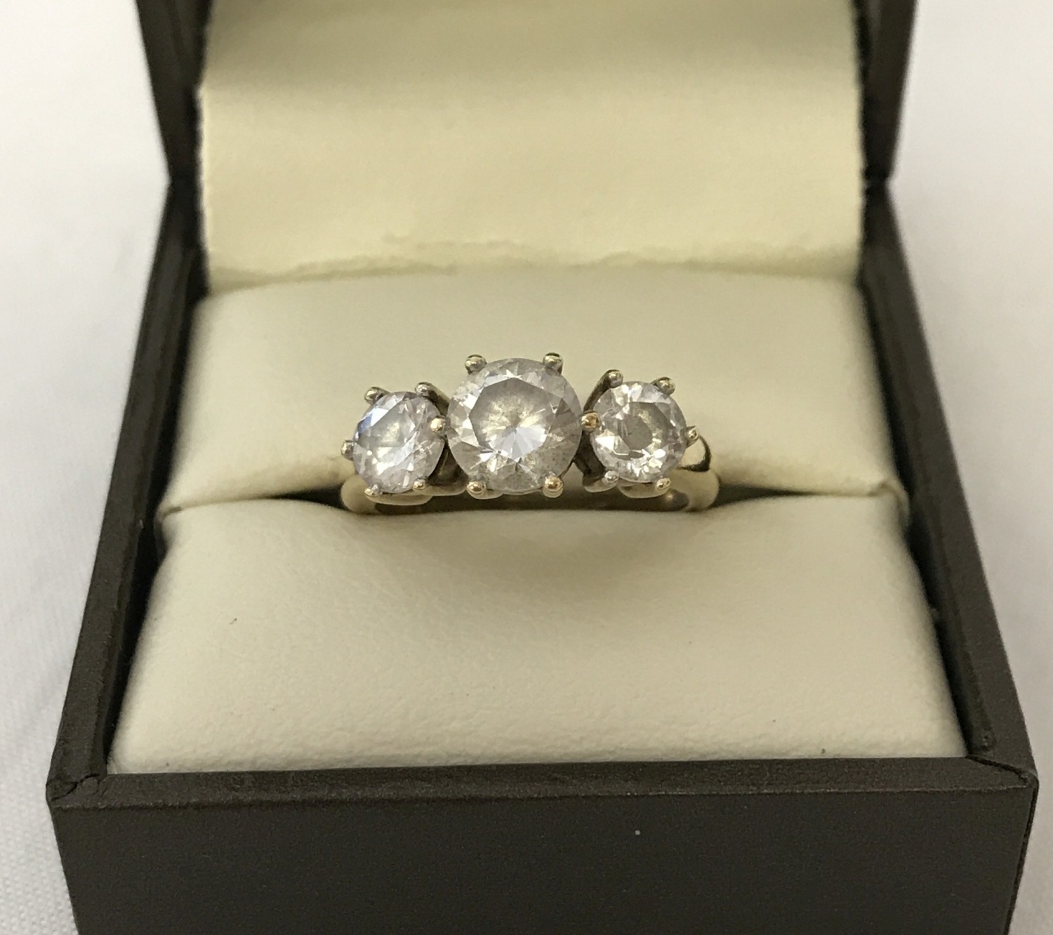 A 9ct gold and clear stone set trilogy ring.