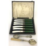 A cased set of silver plate butter knives together with 2 decorative silver plated spoons.
