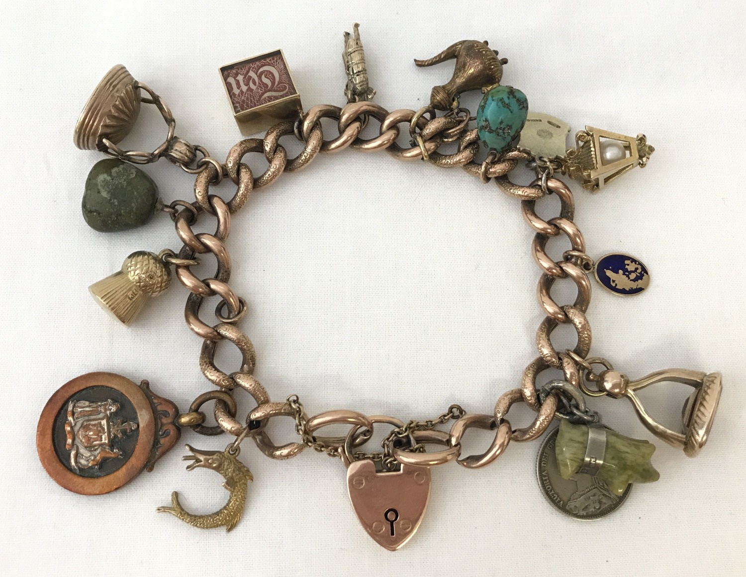 A vintage 9ct chunky rose gold charm bracelet with padlock and safety chain.