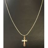 A 9ct gold cross shaped pendant on a fine snake chain. Both cross and chain marked '375'.