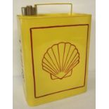A yellow painted 2 gallon Shell petrol can with red detail and brass screw lid.