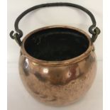 A large Victorian copper cooking cauldron with brass riveted handle brackets.
