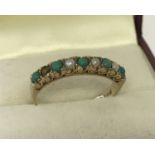 A 9ct gold turquoise & seed pearl set half eternity ring. Scroll decoration to side of stone mount.