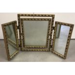 A heavy gilt framed triple dressing table mirror with tilting central mirror.