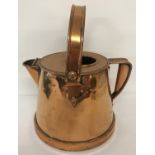 A large antique copper water jug with riveted swing handle.