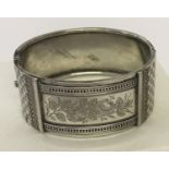 A vintage white metal bracelet with checkerboard and floral engraved panel decoration.
