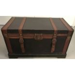 A modern leather bound 2 handled wooden trunk.