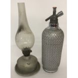 An Art Deco glass and wire mesh Sparklets soda syphon, together with a vintage oil lamp.