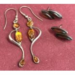 2 pairs of silver earrings set with amber stones. A pair of double oval cut studs.