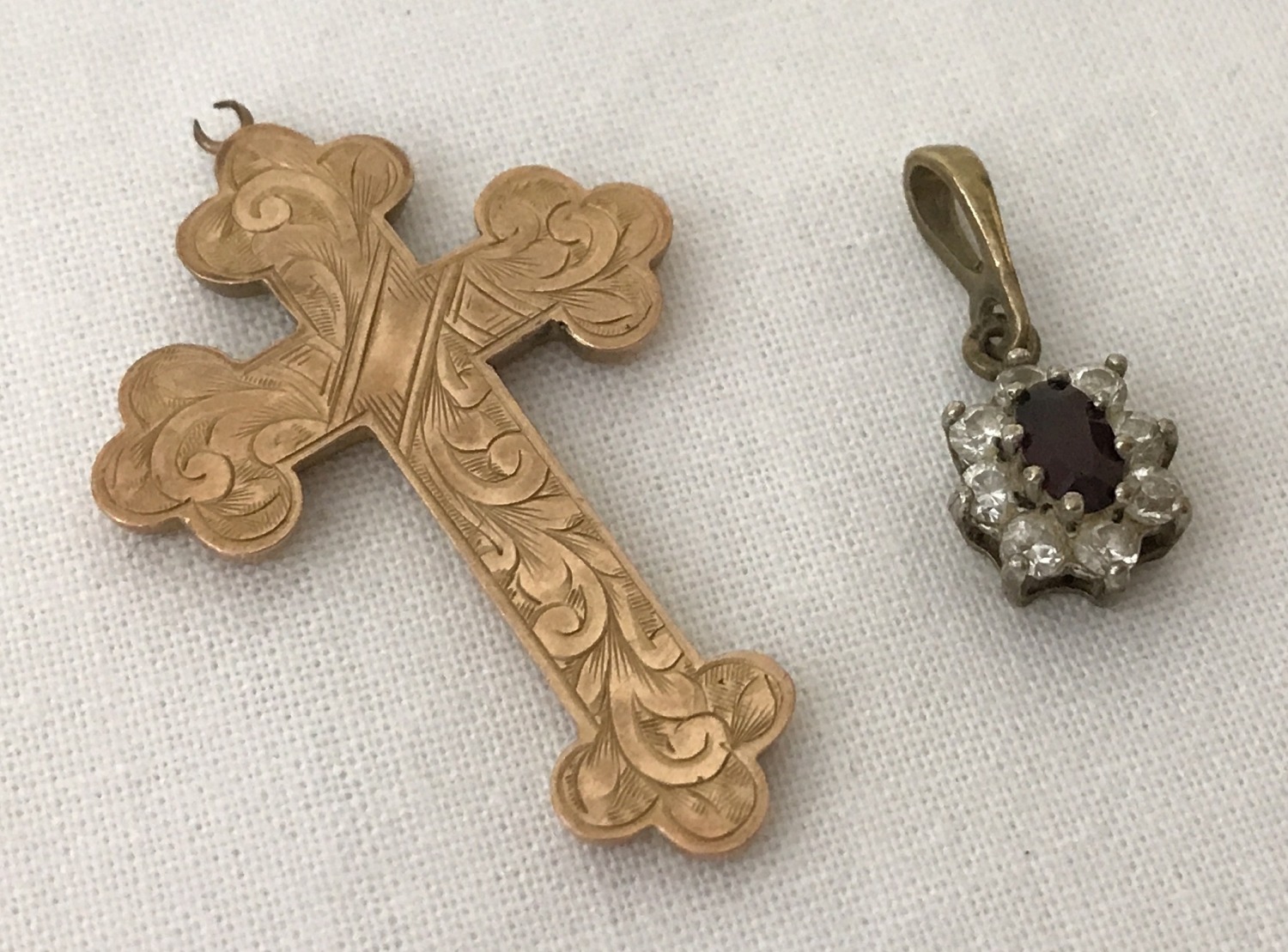 A vintage gold cross pendant with engraved detail to front. Bale needs attention.