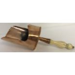 An antique copper scoop with riveted handle and turned bone grip.