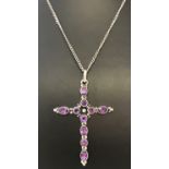 A silver cross pendant set with oval and round cut amethyst stones on a fine curb chain.