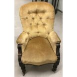 A Victorian wooden framed library chair with turned front legs and ceramic castors.