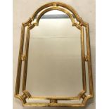 A Modern gilt framed decorative wall hanging mirror with shaped top.