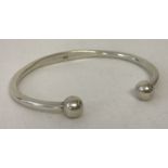 A modern silver torque style bangle. Marked with scales and 925 to inside.