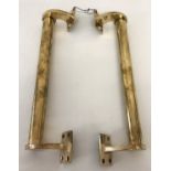 A pair of heavy brass bar door handles.