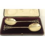 A pair of Edwardian silver gilt serving spoons with Caduceus design to handles. In original case.