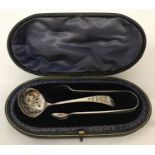 An Edwardian silver sugar sifter spoon and matching sugar nips both with floral engraved detail.