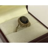 A 9ct gold smoked quartz set dress ring. Central oval cut 2ct smoked quartz stone.