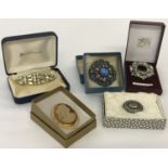 A collection of 5 boxed antique and vintage brooches. To include white metal and stone set.