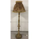 A vintage wooden gilt painted standard lamp with highly turned pedestal, complete with vintage shade