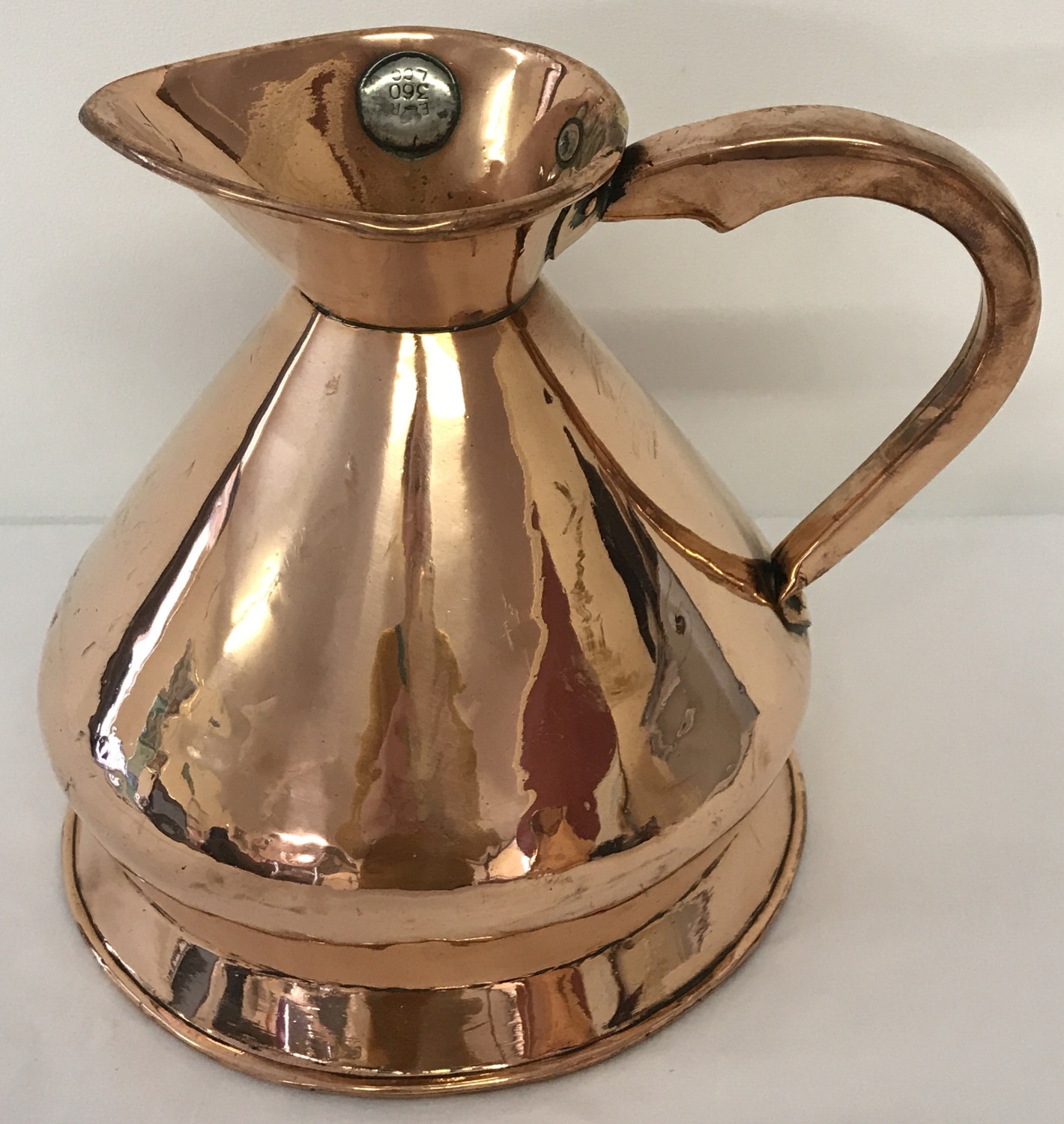 An Edwardian copper half gallon haystack ale jug with leaded ER LCC stamp.