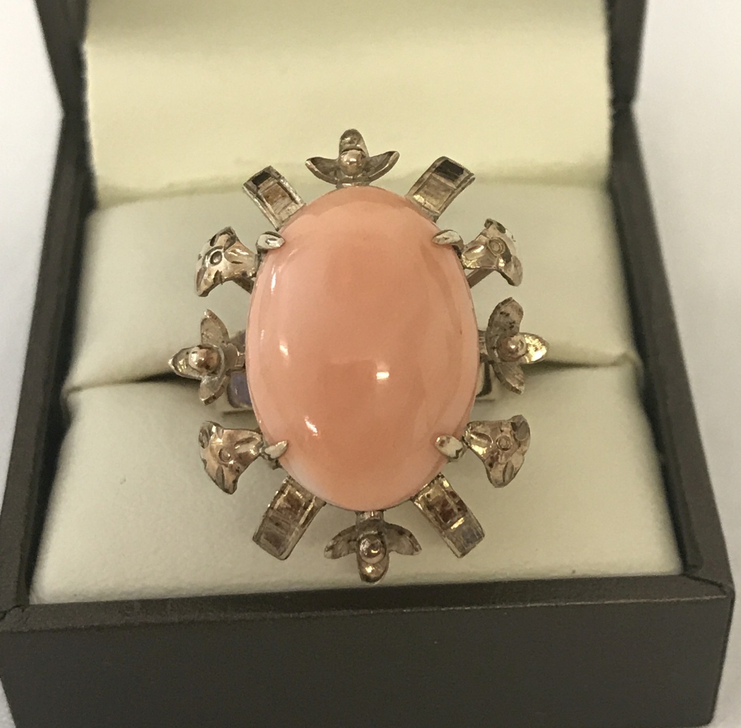 A large vintage coral set cocktail ring. Decorative mount with flower and leaf detail.