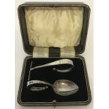 A cased silver baby spoon and pusher. Both with empty cartouche to handles.