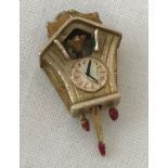 A 9ct gold cuckoo clock charm with coloured enamel detail.