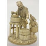 An antique ivory carved figurine of oriental gentleman grinding grain with a small child carrying