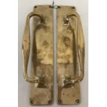 A pair of antique brass door handles mounted on finger plates, with 4 fixing holes.