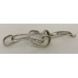 A silver Georg Jenson "Forget Me Knot" brooch by Vivanna Torun.