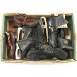 A box of assorted pairs of vintage ice skates.