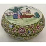 A Chinese enamelled circular lidded pot with brightly coloured floral decoration.