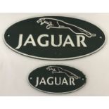2 painted cast metal oval shaped Jaguar plaques.