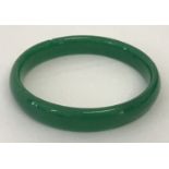 A bright green jade type bangle, approx. 7.5cm diameter.